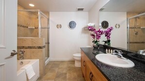 Un baño moderno con bañera, lavamanos, inodoro y zona de ducha.