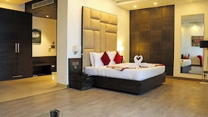 Une chambre d’hôtel moderne avec un grand lit, une armoire et un miroir.