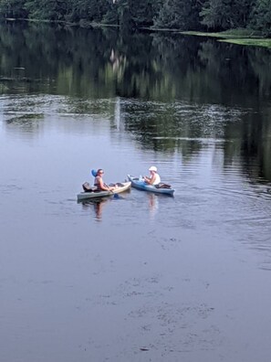 Two people in small boats on a calm lake with trees in the background. - Waterfront lake home w/  fishing, boating, & water activities! (Inverness)