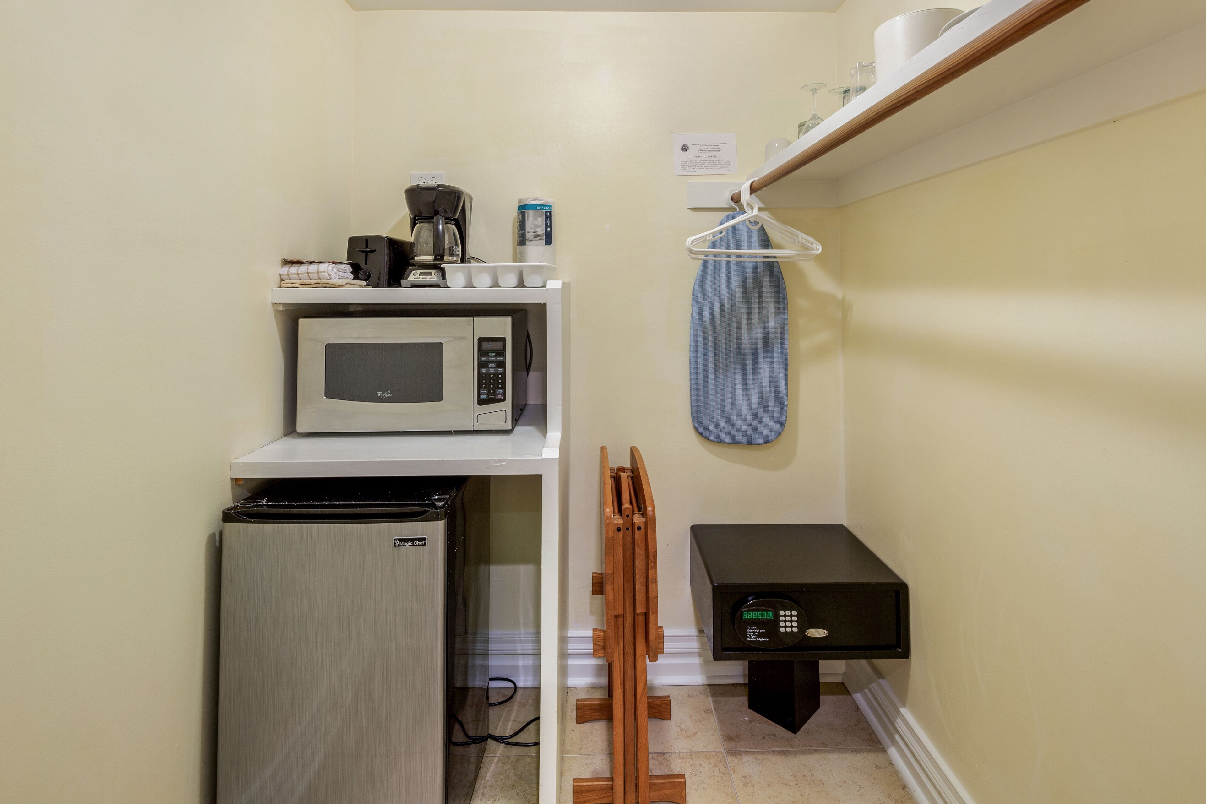 A compact kitchenette with a microwave, coffee maker, and a small refrigerator.