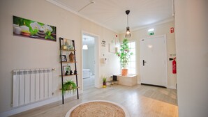 A hallway with a radiator, a woven rug, a potted plant, a framed picture, and a door. - Holiday Home Villa As Cumadres with Mountain View, Pool, Garden & Wi-Fi (Azeitão)