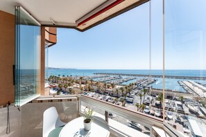 A balcony with a view of a marina, a potted plant, and a white chair. - 'Stunning Marina View Apartment' with Wi-Fi (Fuengirola)