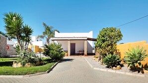 A residential building with a paved driveway, a covered porch, and various plants. - Vacation Home "Casa La Vigía" with Private Pool, Private Terraces & Wi-Fi (Conil de la Frontera)