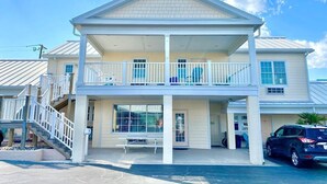 A two-story building with a balcony, a staircase, and a covered front porch. - Pet-friendly, 3 Blocks to Beach, Pool, #105 (Atlantic Beach)
