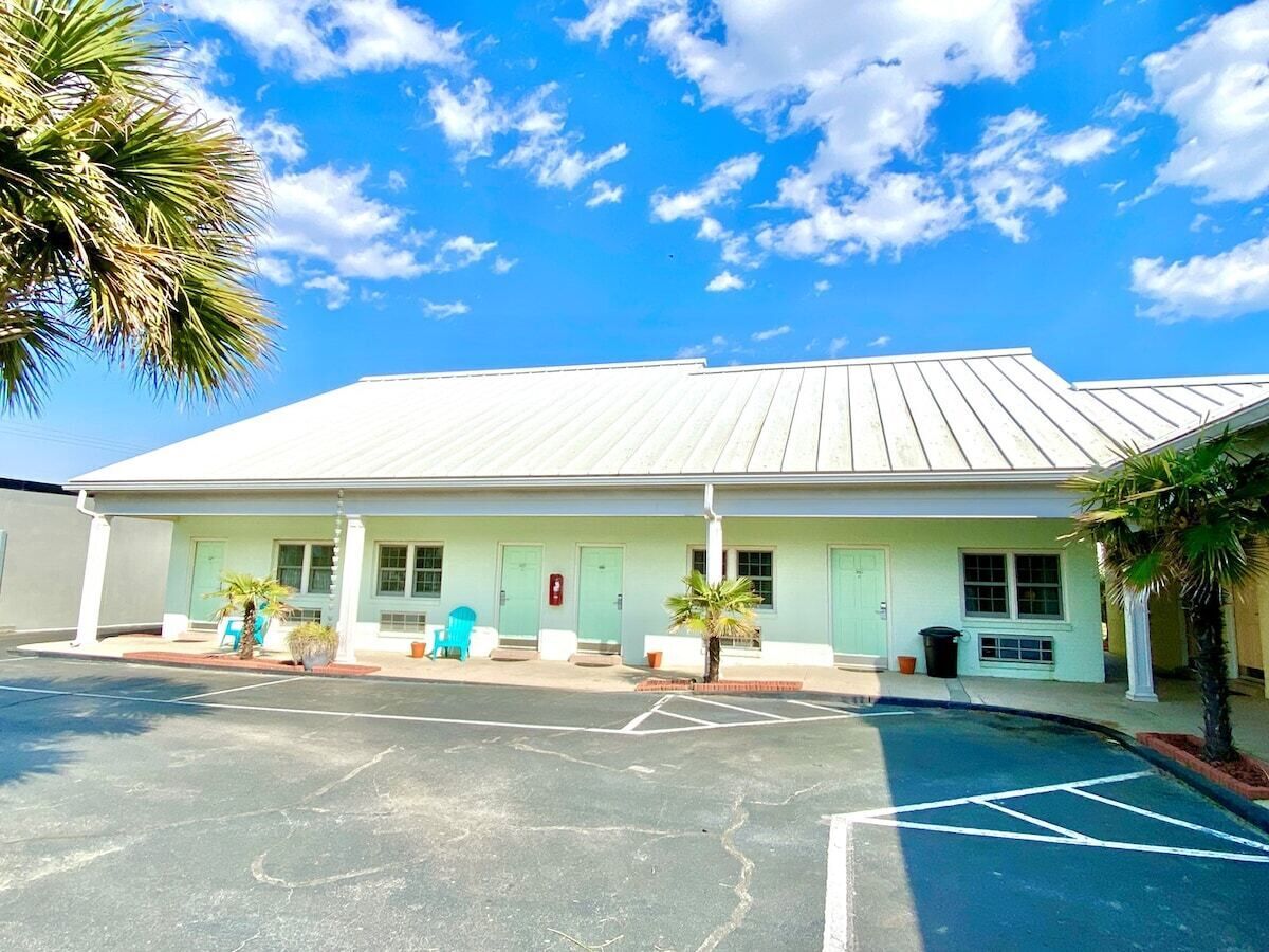 A building with a flat roof, a covered front porch, and a parking lot.