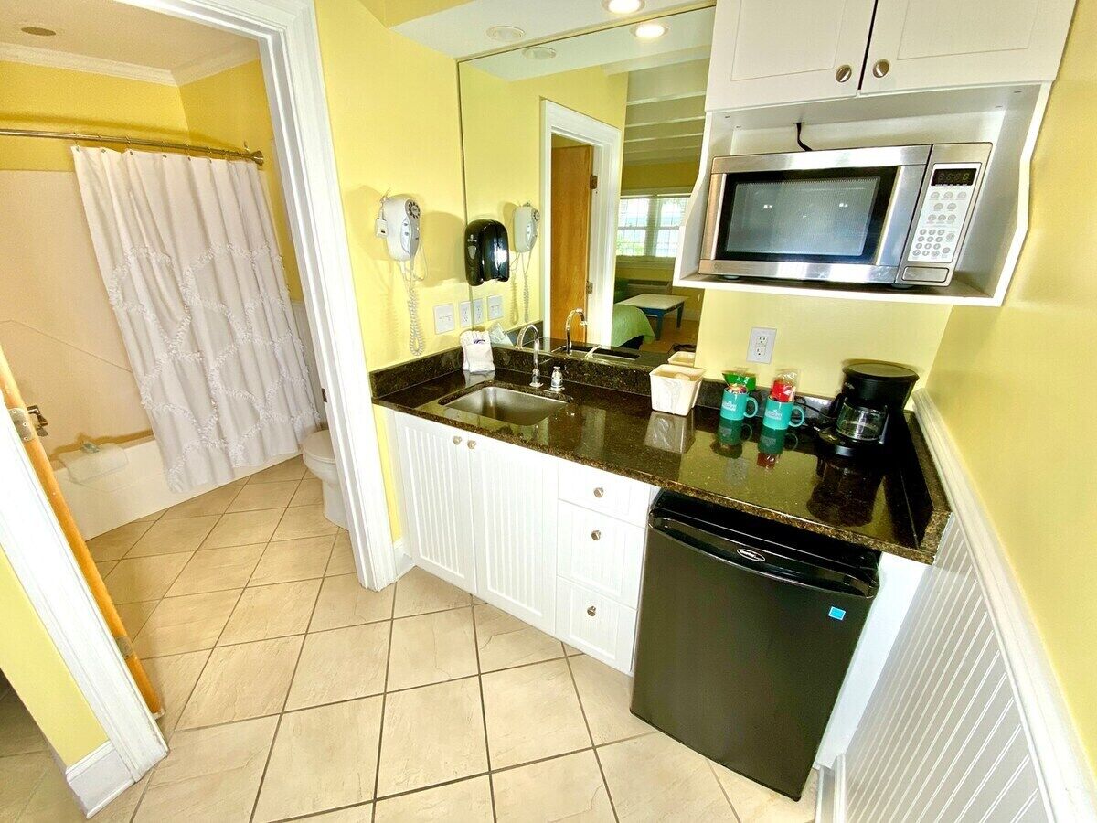 A compact kitchen with a microwave, coffee maker, and dishwasher.