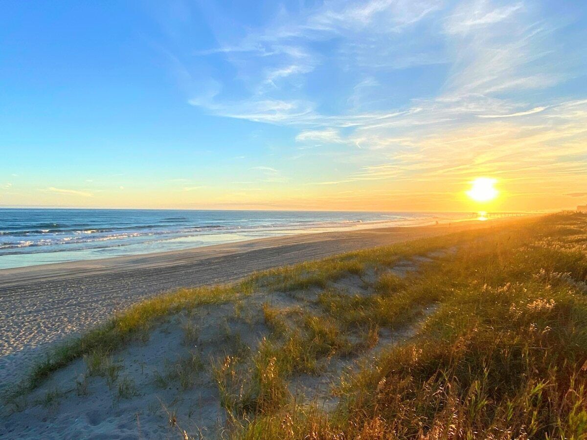 Une plage avec des dunes de sable et l’océan.