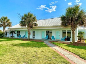 A single-story house with a front porch, two blue chairs, and a palm tree. - Pet-friendly, 3 Blocks to Beach, Pool, #304 (Atlantic Beach)