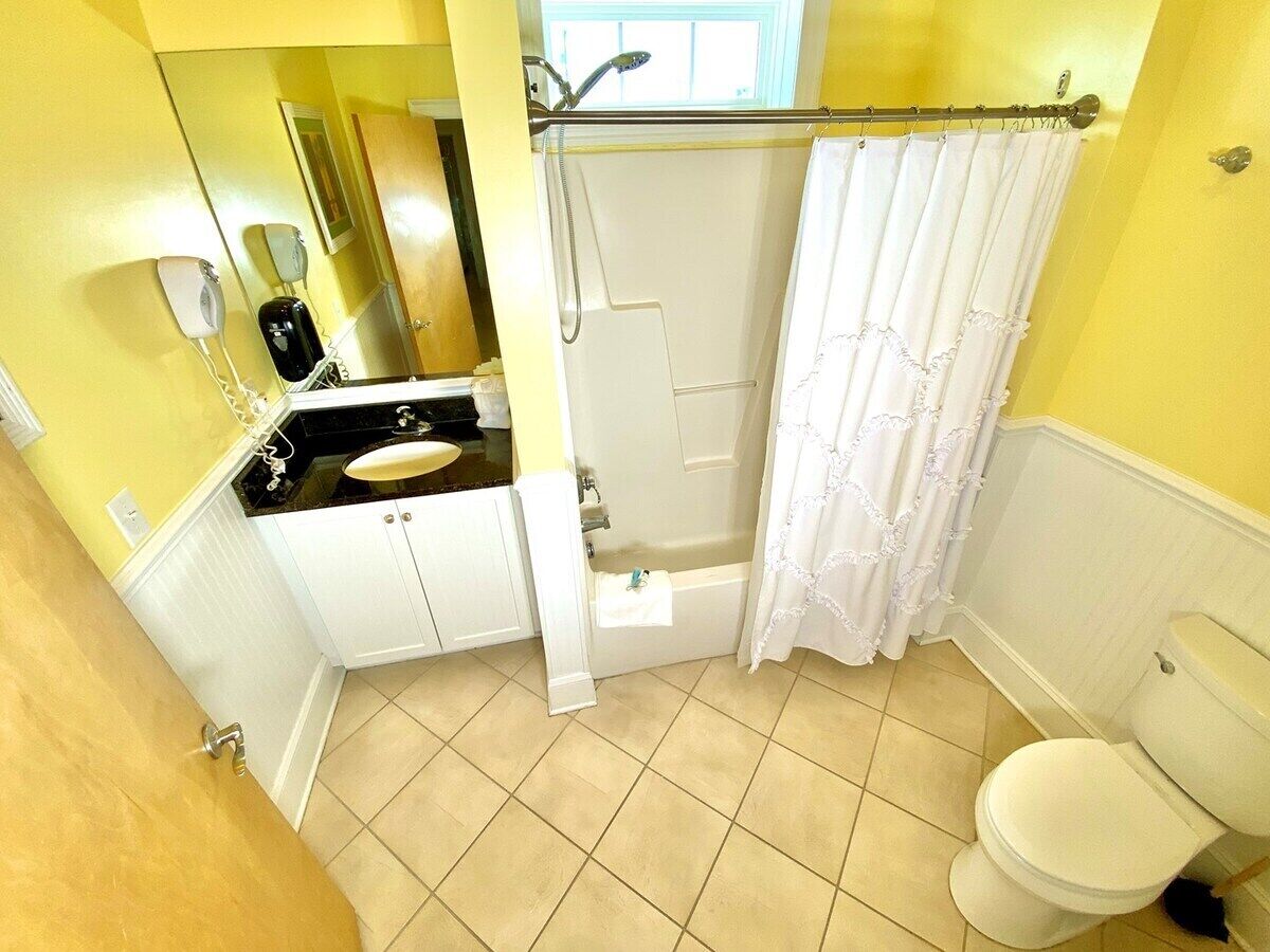 Un bagno con vasca, servizi igienici e lavandino.