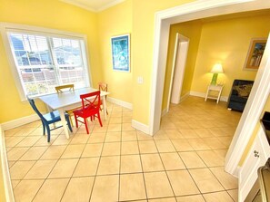 A dining area with a table and chairs, a window with blinds, and a door leading to another room. - Pet-friendly, 3 Blocks to Beach, Pool, #501 (Atlantic Beach)