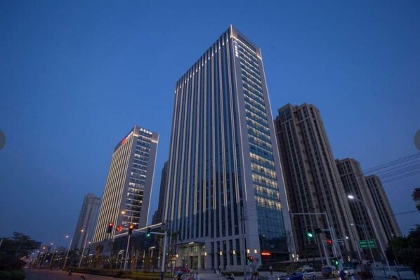 Un edificio de gran altura con un diseño moderno, que presenta un llamativo patrón de líneas verticales en su fachada.