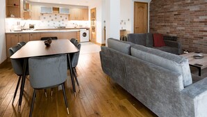Ein modernes Wohnzimmer mit einem grauen Sofa und einem Esstisch mit Stühlen.