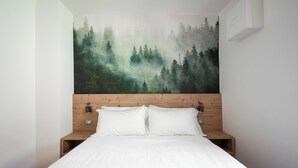 A bedroom with a large forest mural on the wall, a wooden headboard, and a neatly made bed with white linens. - Italianway - Belvedere 28 (Valdidentro)