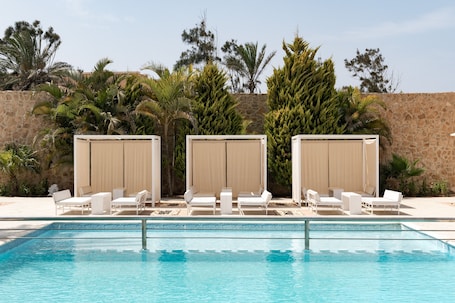Una piscina al aire libre, sillones reclinables de piscina