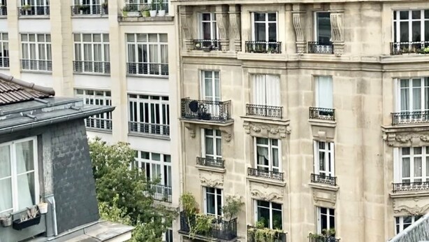 Un edificio de varios pisos con balcones, ventanas grandes y un estilo arquitectónico clásico.