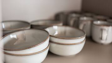 A collection of white ceramic bowls with copper rims, arranged on a surface.