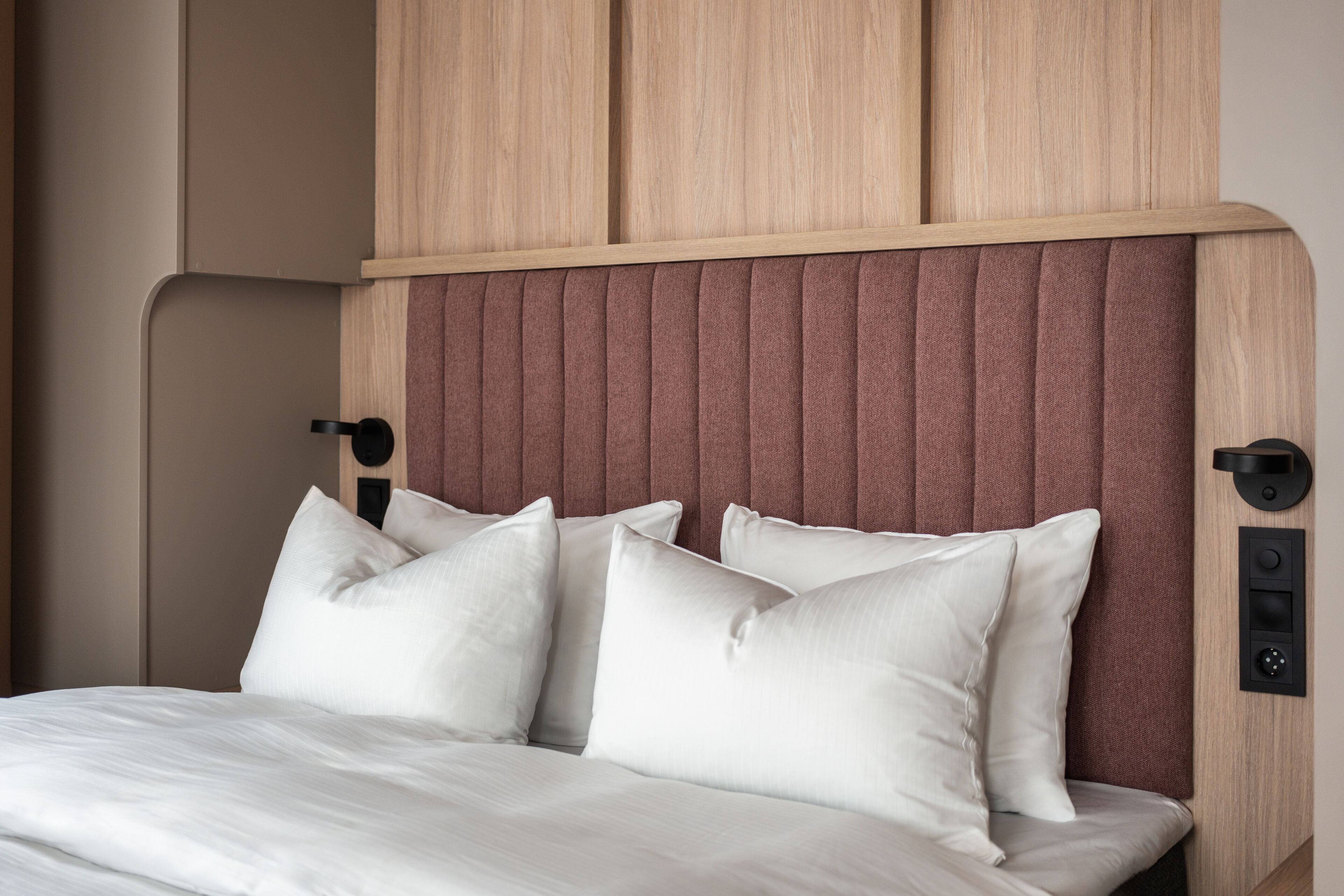 A bed with white bedding and a headboard with vertical slats.