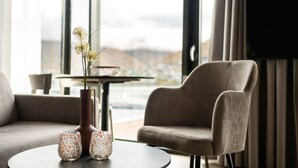 A modern living room with a sofa, a chair, a round table, and a vase with flowers. - Skaret by Vander (Tromsø)