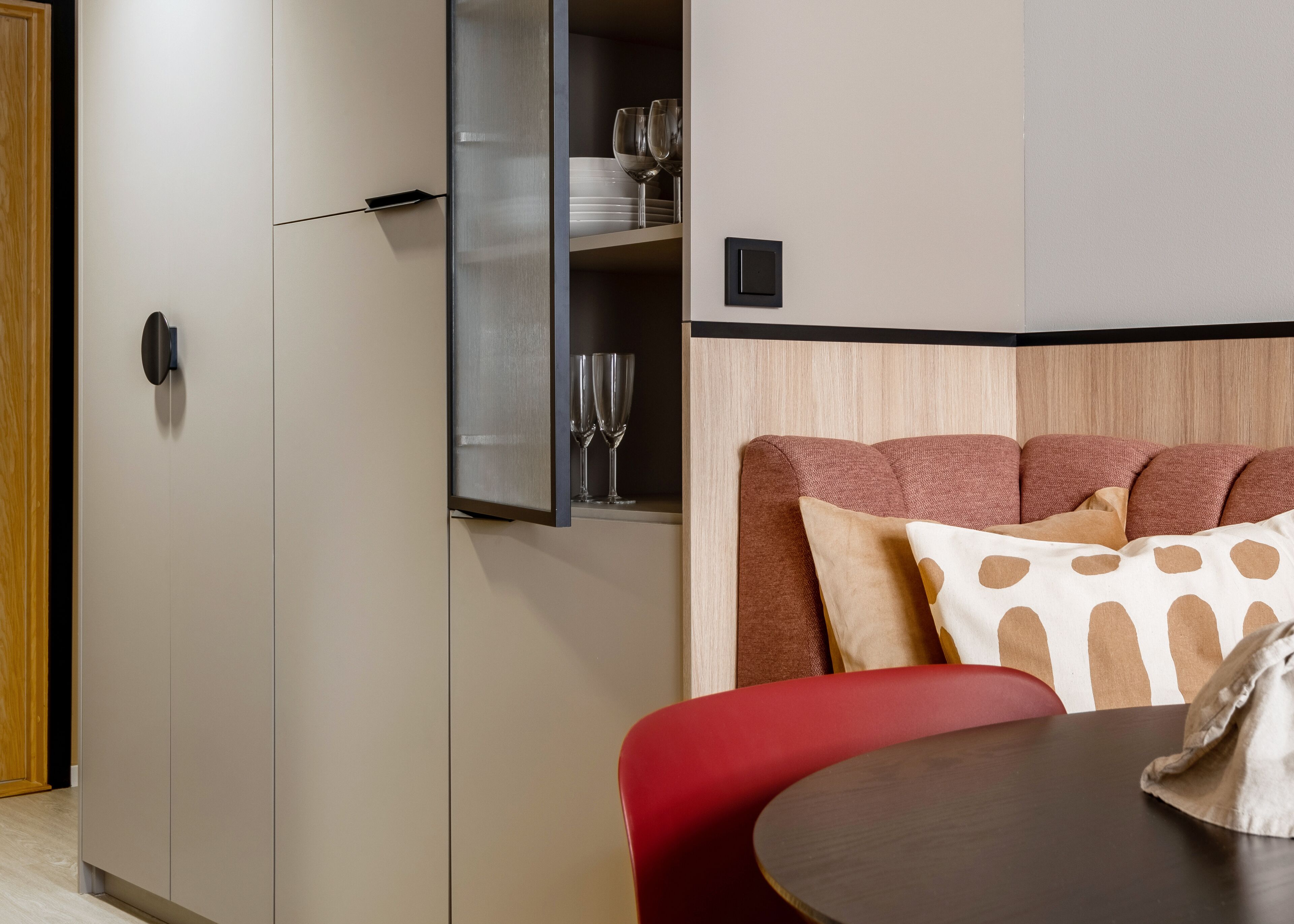 Een kleine kamer met een bed, een tafel en een kledingkast.