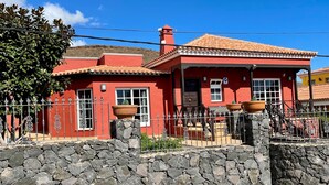 A red house with a tiled roof, stone wall, and metal fence. - Spacious Villa in Quiet Location Close to Resorts (Buzanada)