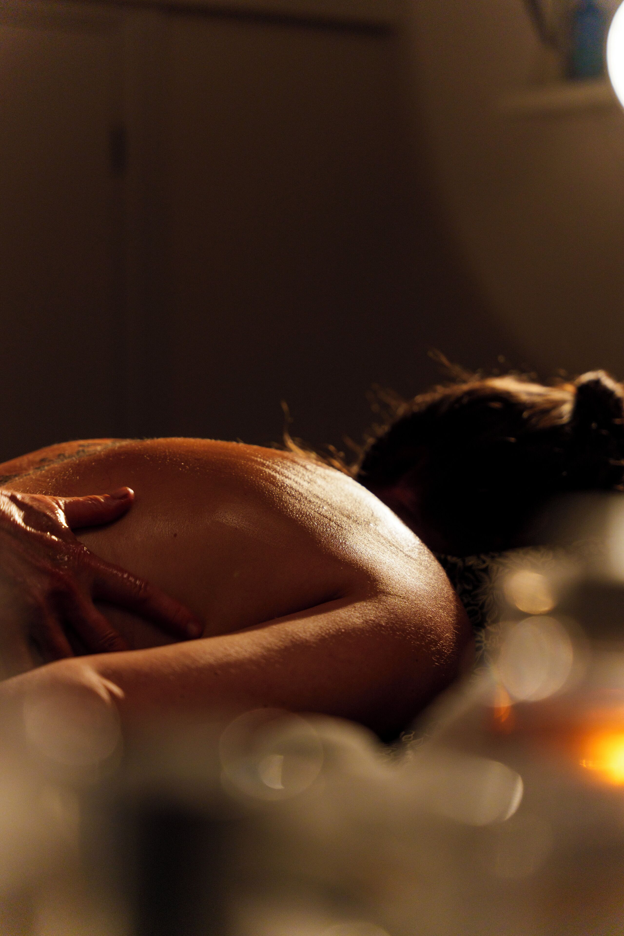 A dimly lit room with a person lying down, suggesting a private space.