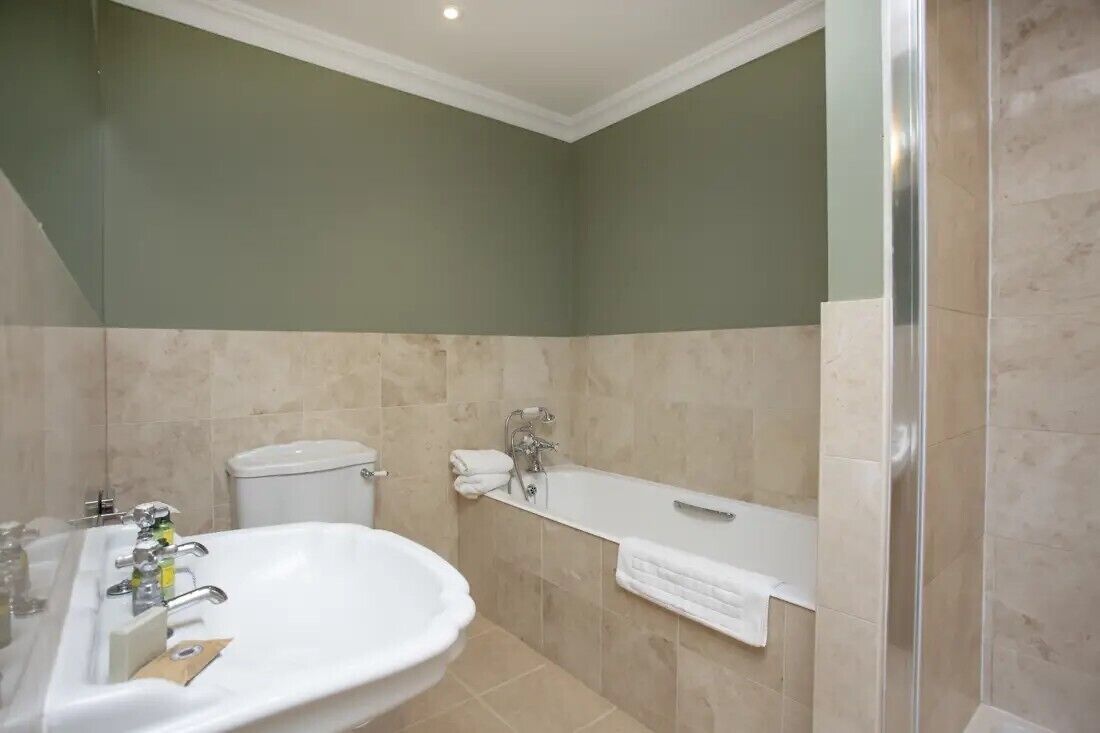 Een badkamer met een wastafel, toilet en bad.