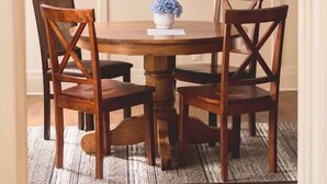 A dining area with a wooden table and four chairs, a welcome sign on the wall, and a ceiling fan. - That Corner Lot-Charming Downtown Home w/Side Yard (Troy)