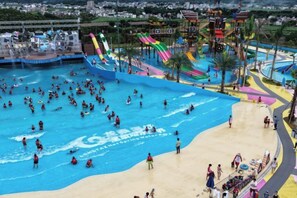 A large outdoor swimming pool with multiple slides and a sandy beach area. - Long Tai Hotel (Wengyuan)