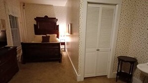 Ein Schlafzimmer mit Bett, Kommode und Kleiderschrank.