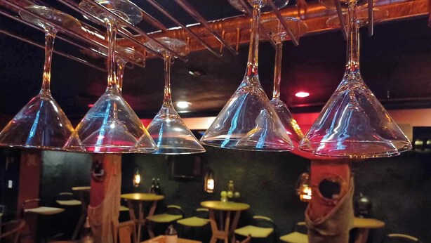 A restaurant interior with multiple tables and chairs, hanging conical light fixtures, and a wooden ceiling. - AH #28 · AH #28 King w/Jacuzzi/SS/Fridge/Micro (Wabasha)