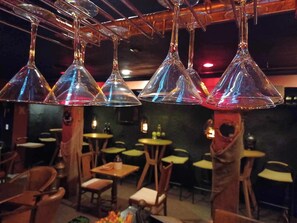 A restaurant interior with multiple tables and chairs, hanging conical light fixtures, and a wooden ceiling. - AH #28 · AH #28 King w/Jacuzzi/SS/Fridge/Micro (Wabasha)