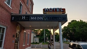 Une enseigne d’hôtel indiquant « HÔTEL ANDERSON » et « CHAMBRES D’HÔTES ET RESTAURANT », signalant un bâtiment historique doté d’un restaurant.