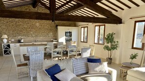 Un salón amplio con una pared de piedra, un comedor y una zona de estar acogedora.