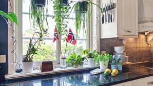 Una cocina con ventana, varias plantas en macetas y utensilios.
