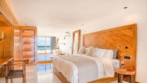 Ein geräumiges Schlafzimmer mit einem großen Bett, einem Holzkopfende und Blick ins Freie.