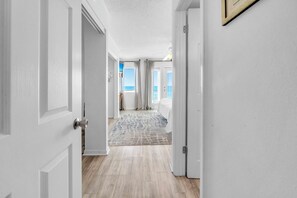Un corridoio con un tappeto decorato che conduce a una camera da letto vista mare.