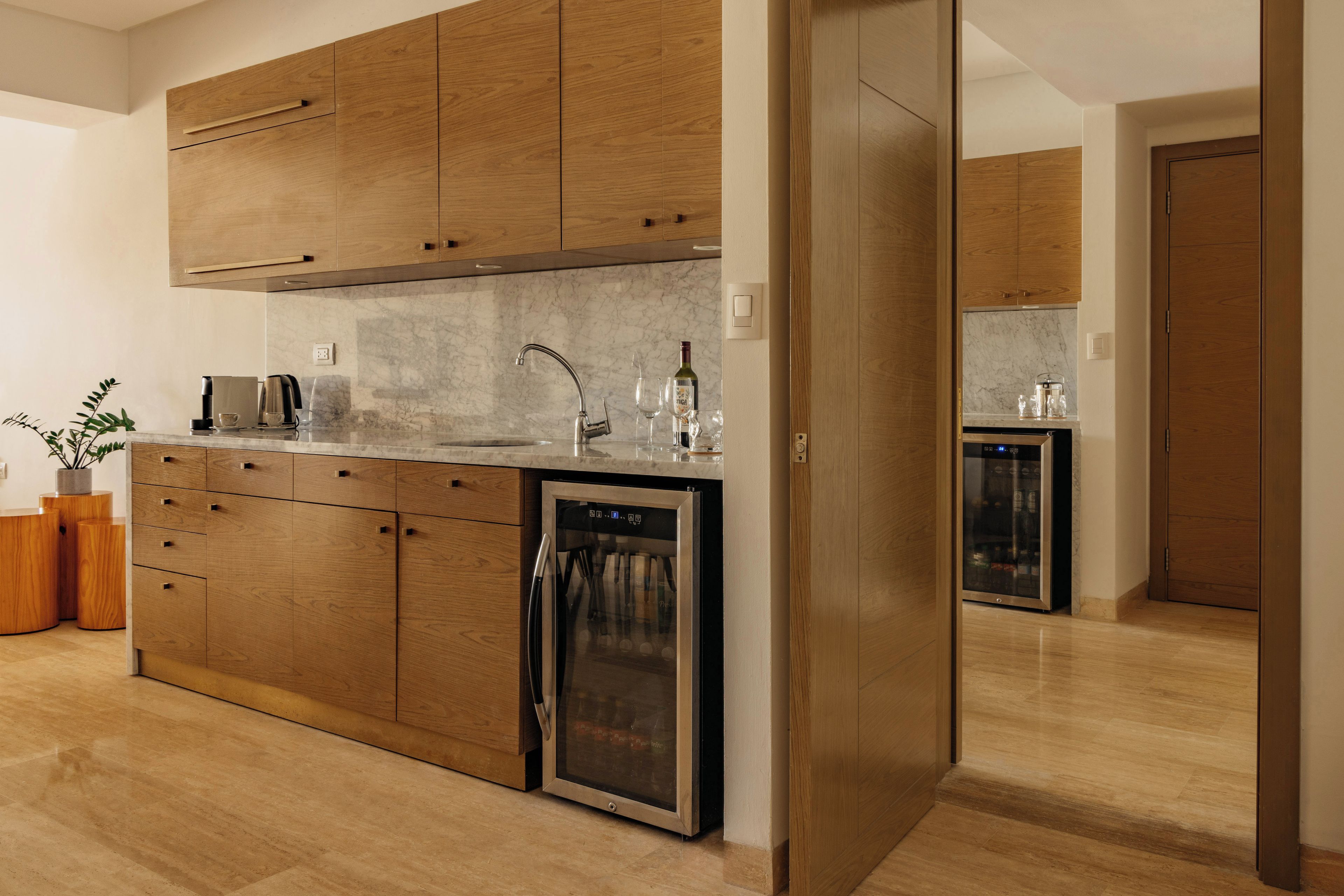 Eine moderne Küche mit Holzausstattung, einem eingebauten Geschirrspüler und einer Marmorarbeitsplatte.
