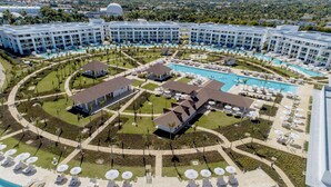 A resort with multiple swimming pools, sun loungers, and a central pavilion. - Paradisus Grand Cana - All Suites - All Inclusive (Punta Cana)