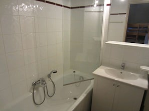 Un baño con bañera, ducha y lavamanos.