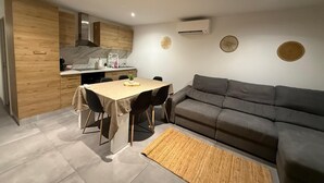 Un espace de vie compact comprenant un coin repas, un canapé et une cuisine.