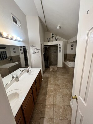 A spacious bathroom with a large vanity, a shower, and a bathtub.