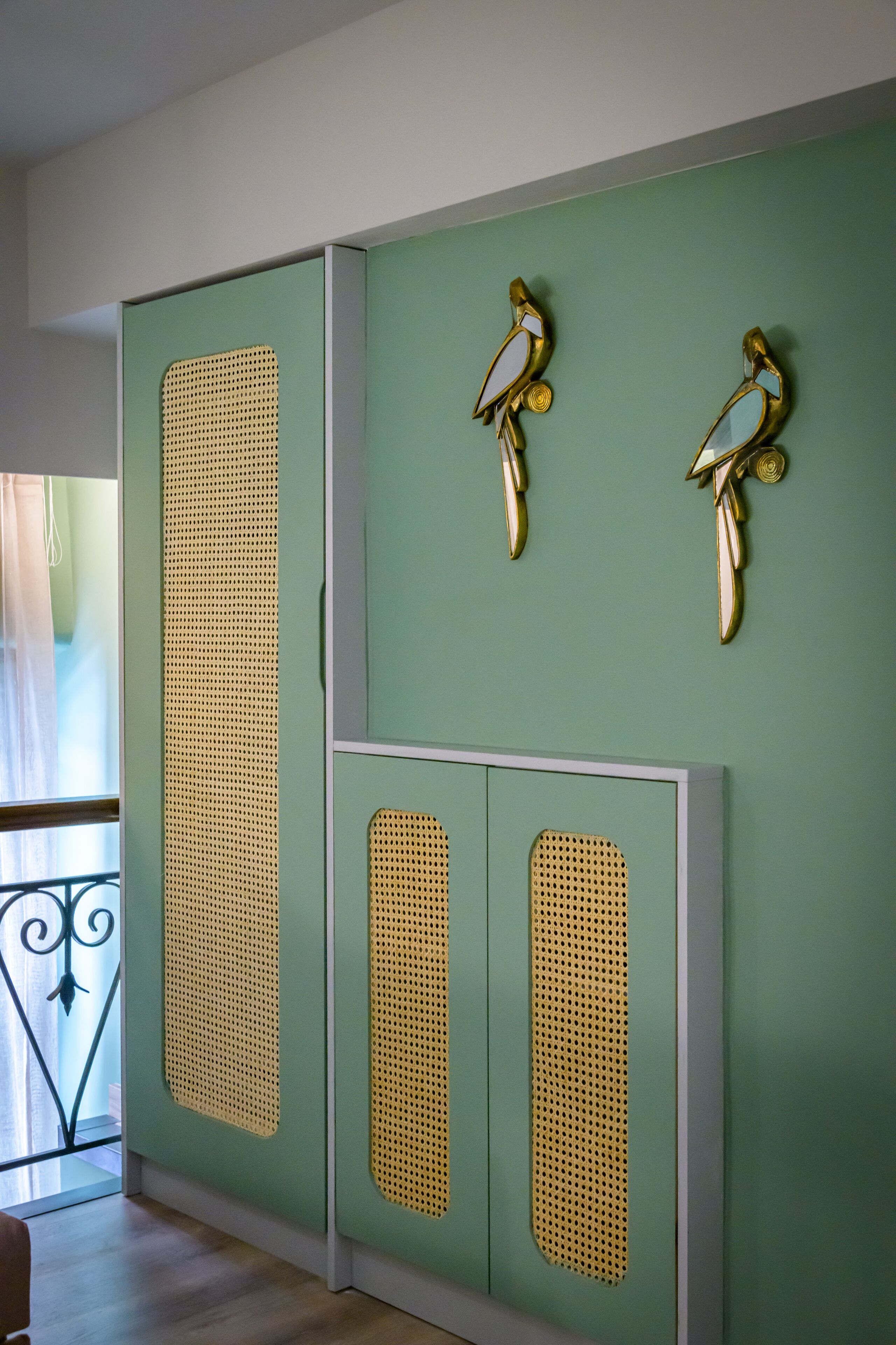 Una habitación con un separador verde decorado y un ventanal con vistas.