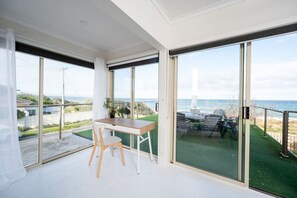 Enjoy a serene view of the water from this room, which offers a sliding glass door leading to an outdoor area with a seating space.