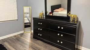A bedroom with a black dresser, a large mirror, and two golden elephant figurines on top. - Fayetteville, NC, close to I-295 and Fort Bragg (Fayetteville)