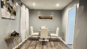 A dining area with a table and four chairs, a gold floor lamp, and a framed picture on the wall. - Fayetteville, NC, close to I-295 and Fort Bragg (Fayetteville)