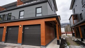 A modern two-story residential building with a garage and a balcony.