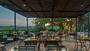 An outdoor dining area with tables set for two, equipped with wine glasses and candles, overlooking a lush landscape. - The Lodge Mallorca - Small Luxury Hotels (Sa Pobla)