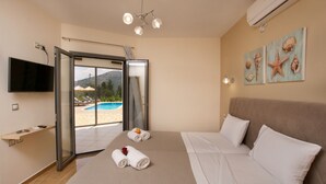 Habitación de hotel con cama, televisión, vista a la piscina y vista a la playa.