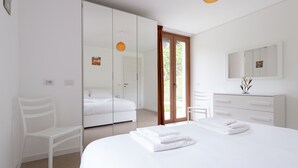A modern bedroom with a large bed, a wardrobe, a desk, and a mirror. - Italianway - Villa Tola (Valdisotto)