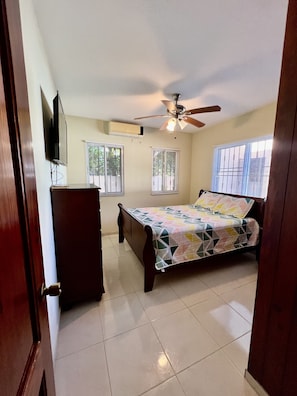 Relax in this cozy bedroom with a comfortable bed, ceiling fan, and television.